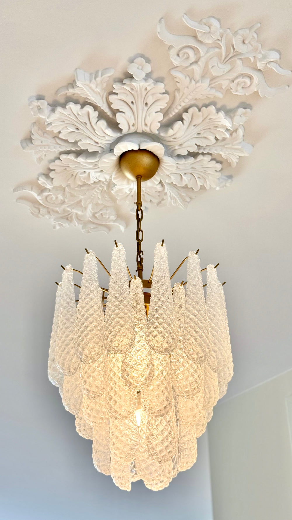 Lit drop glass chandelier with a brass ceiling cup
