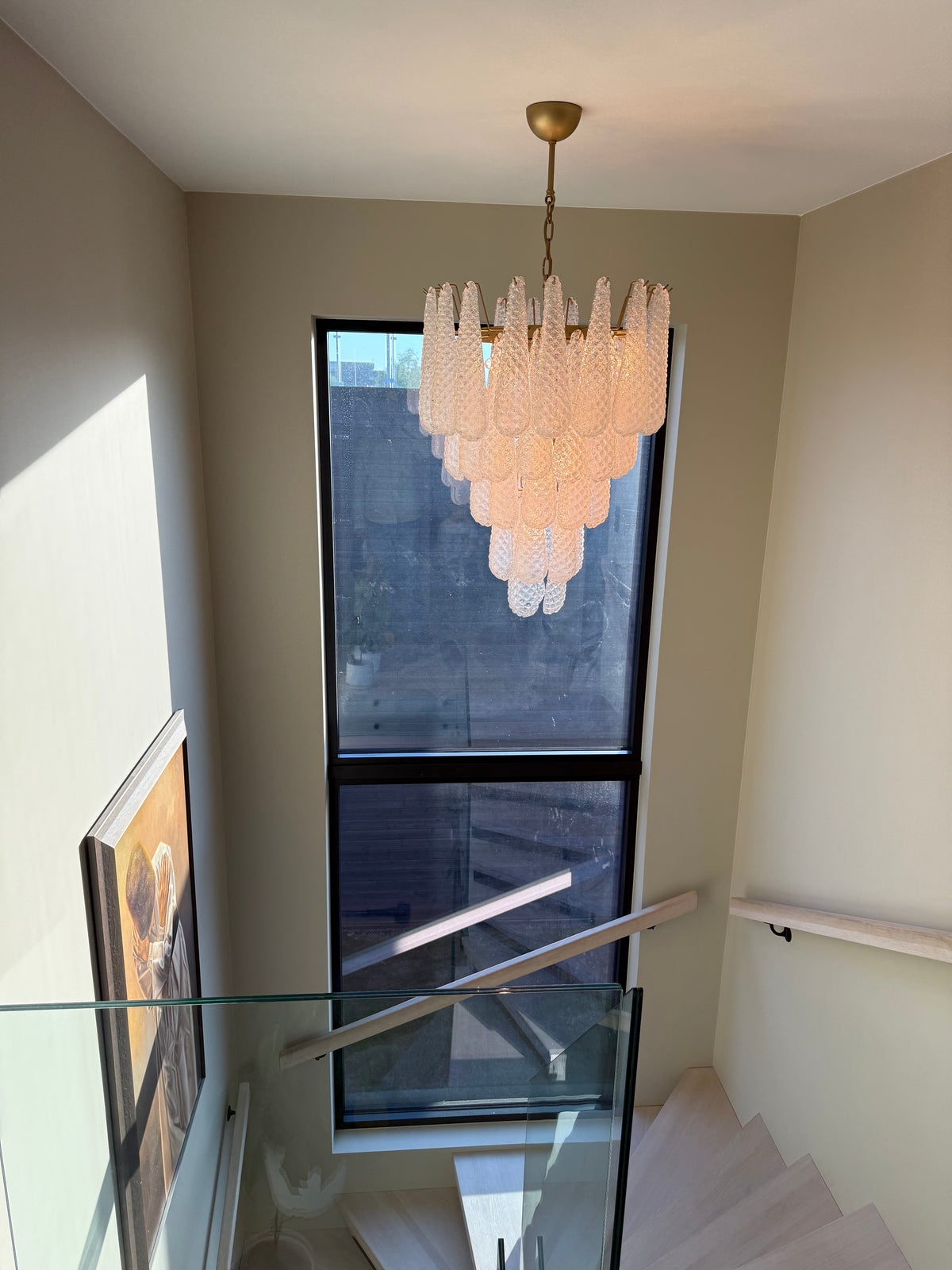 Drop glass chandelier in a stairwell with a tall window